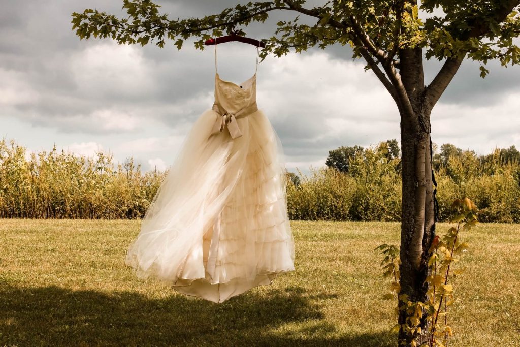 Bild på en brudklänning som hänger på ett träd